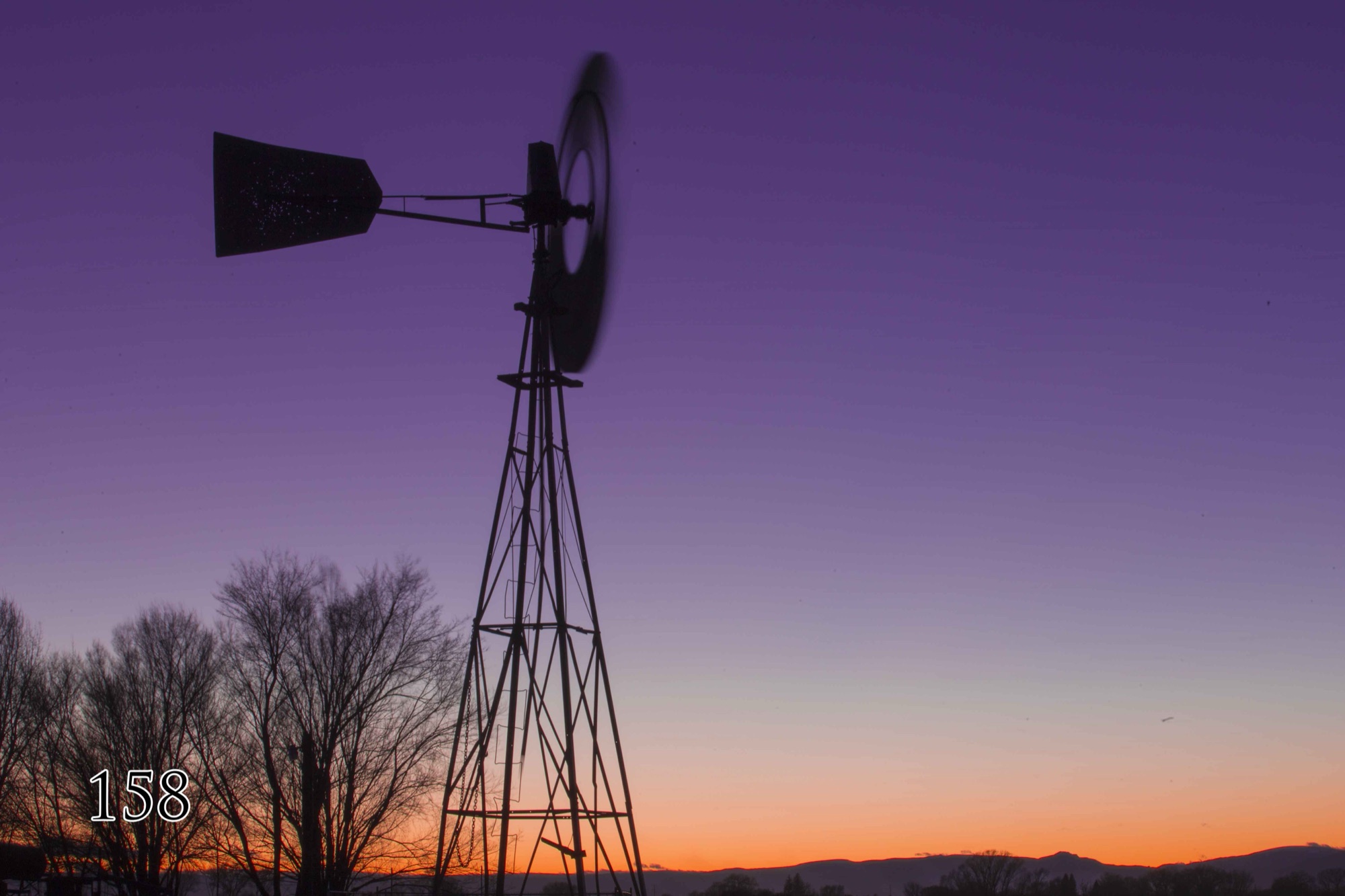 Windmill silhouetted at sunset on the refuge